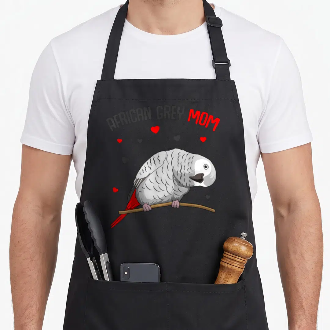 Parrot african aprons for women - African Grey Mom text above a grey parrot on a branch surrounded by red and grey — shown on a black cotton canvas apron against a white background