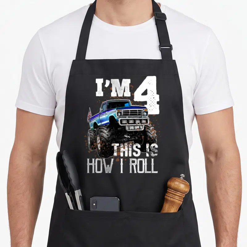 Roll monster truck apron - Blue monster truck with I'M 4 U.S.A text and mud splatters — shown on a black cotton canvas apron against a white background