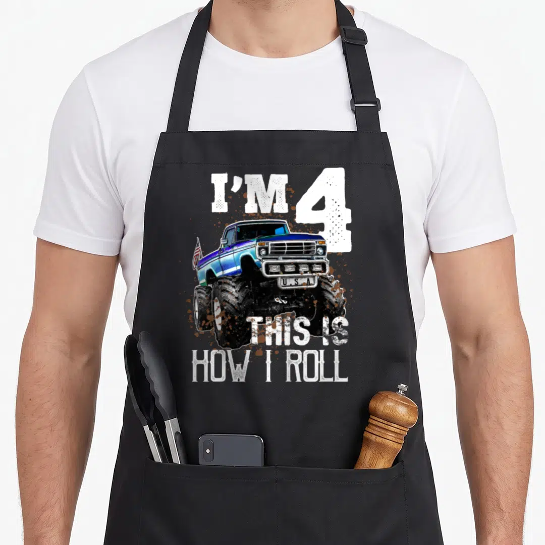 Roll monster truck apron - Blue monster truck with I'M 4 U.S.A text and mud splatters — shown on a black cotton canvas apron against a white background