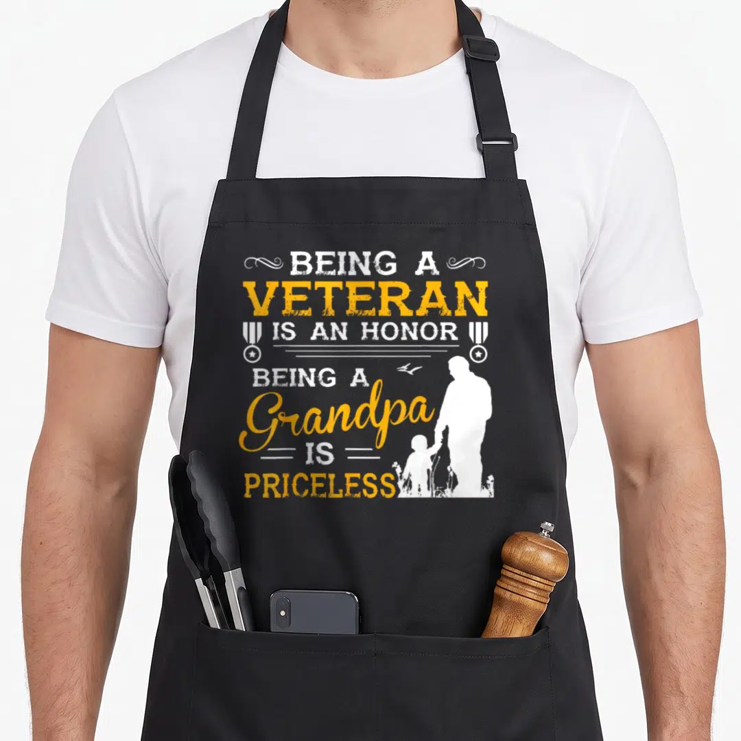 Grandfather grandpa apron - Distressed text reading Being a Veteran Is An Honor Being a Grandpa Is Priceless — shown on a black cotton canvas apron against a white background