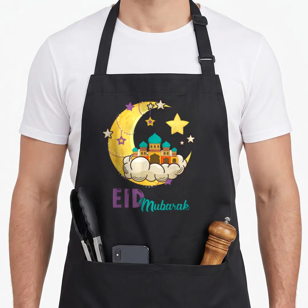 Legend eid apron - Cartoon mosque on cloud inside yellow crescent moon with purple and teal EID Mubarak text — shown on a black cotton canvas apron against a white background