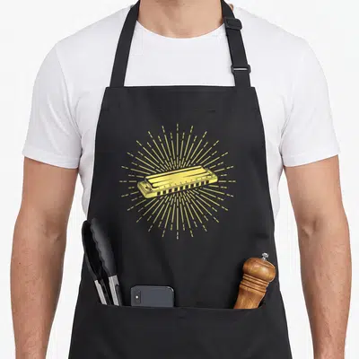 Harmonicist french apron - Yellow line-art harmonica with radiating dashed lines and numbered holes 1 to 10 — shown on a black cotton canvas apron against a white background