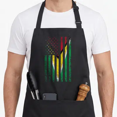 Guyana pride american flag apron - Vertical distressed flag stripes in red yellow green black with multicolored stars — shown on a black cotton canvas apron against a white background