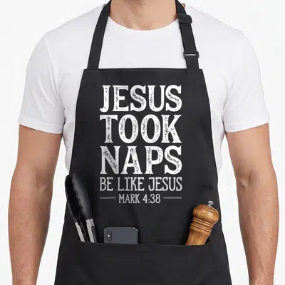 Took christian apron - White stacked typography reading JESUS TOOK NAPS BE LIKE JESUS MARK 4:38 — shown on a black cotton canvas apron against a white background