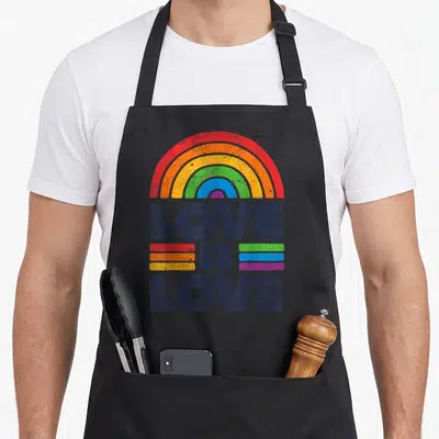 Ally rainbow flag gay pride apron - LOVE IS LOVE text under rainbow arch with colored stripes in distressed print — shown on a black cotton canvas apron against a white background