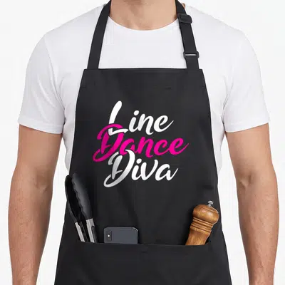 Line country apron - Stacked white and pink script reading Line Dance Diva — shown on a black cotton canvas apron against a white background