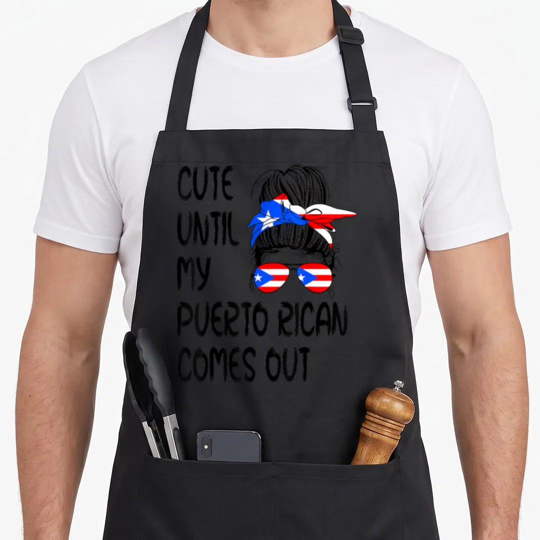 Rican puerto boy apron - Stacked text next to woman with flag sunglasses and bun in line art — shown on a black cotton canvas apron against a white background