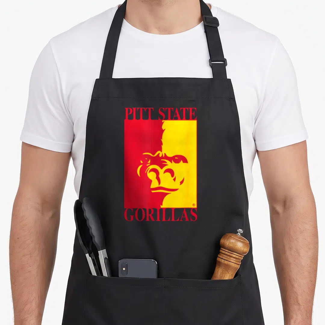 Pittsburg best university ever apron - Red and yellow split rectangle with stylized gorilla head and Pitt State — shown on a black cotton canvas apron against a white background