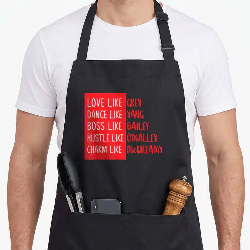 Twisty anatomy apron - Red and white stacked text on grey background quoting TV show characters — shown on a black cotton canvas apron against a white background