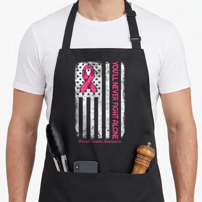 Youll breast cancer awareness aprons - Pink ribbon over distressed white flag with vertical text and script — shown on a black cotton canvas apron against a white background
