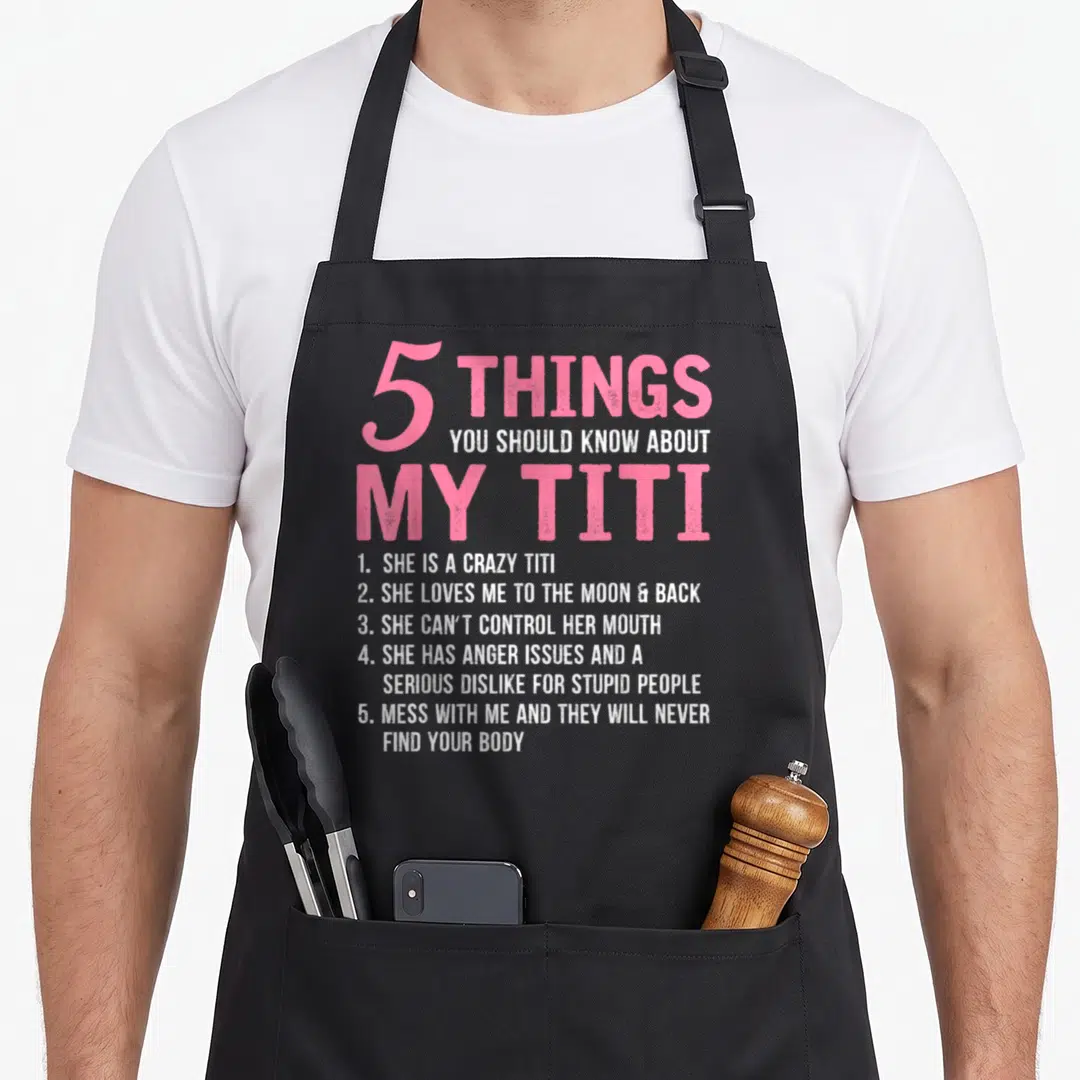 Should titi grandma apron - Pink and white text listing 5 things about My Titi including anger issues and moon back love — shown on a black cotton canvas apron against a white background