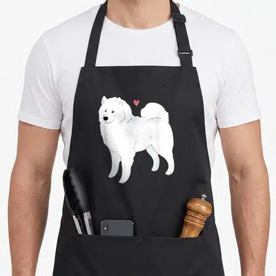 Sammy dog apron - White cartoon Samoyed dog standing with small red heart floating above head — shown on a black cotton canvas apron against a white background