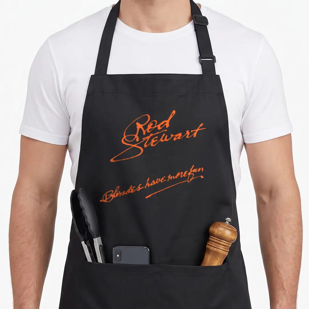 Stewart rod girl apron - Orange script typography reading Rod Stewart and Blondes have more fun on three stacked lines — shown on a black cotton canvas apron against a white background