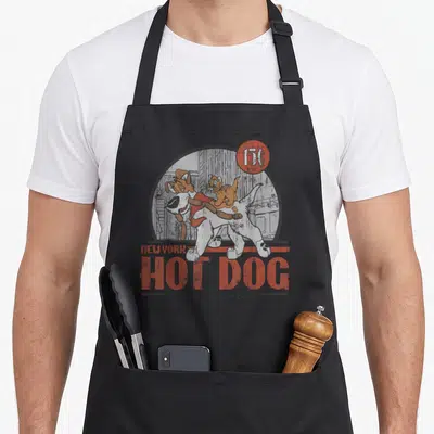 Oliver hot dog apron - Retro graphic of a dog and cat in a grey circle with stacked text reading 15C NEW YORK HOT DOG — shown on a black cotton canvas apron against a white background