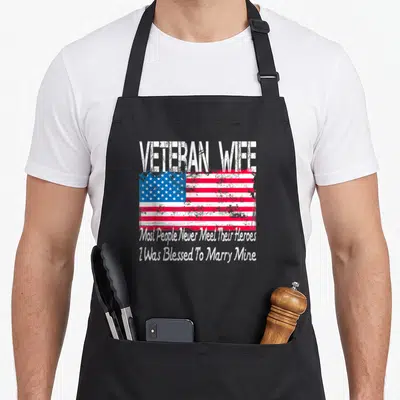 Blessed wife apron - Distressed USA flag with veteran wife text and marriage blessing quote — shown on a black cotton canvas apron against a white background