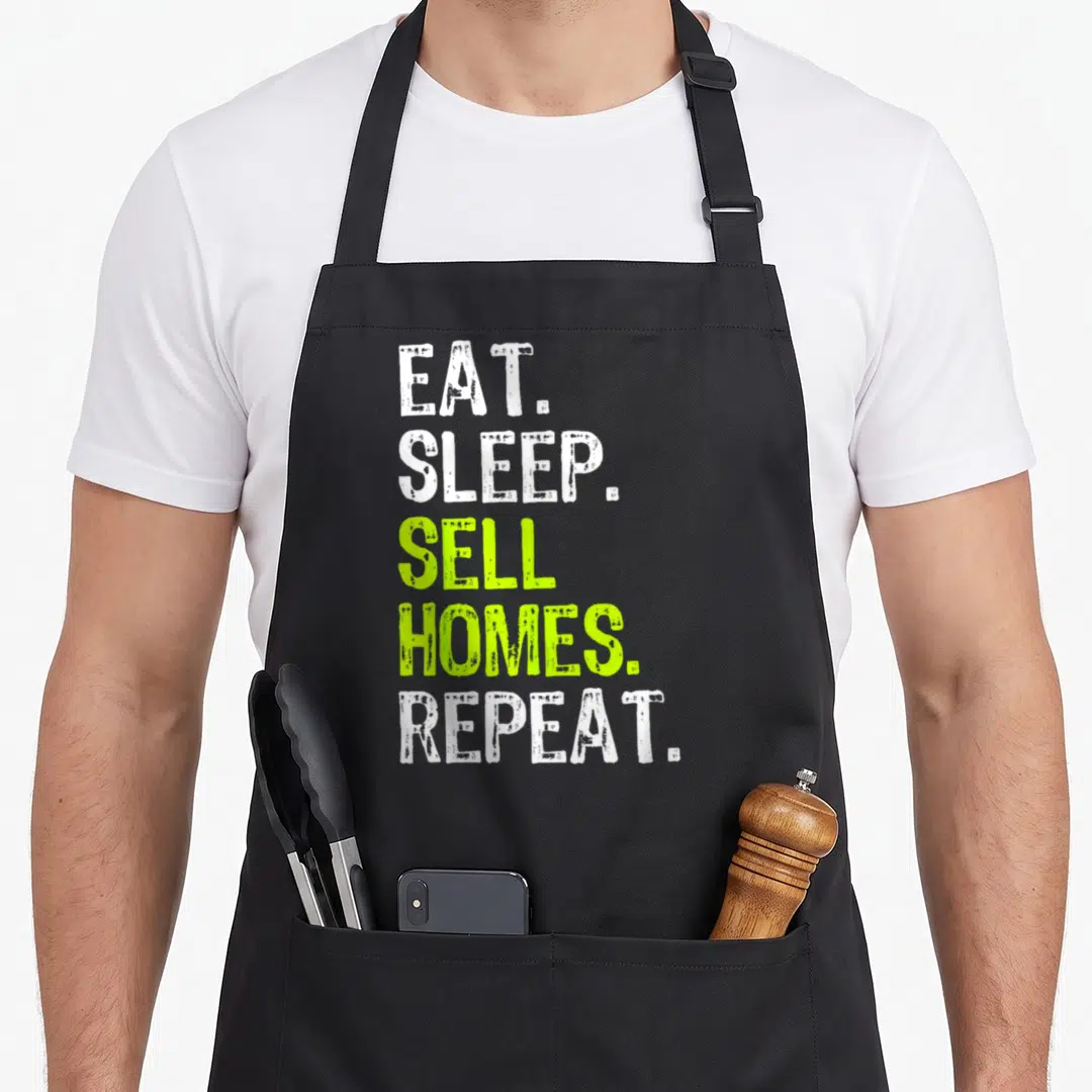 Eat realtor apron - Stacked white and lime green text reading EAT. SLEEP. SELL HOMES. REPEAT — shown on a black cotton canvas apron against a white background