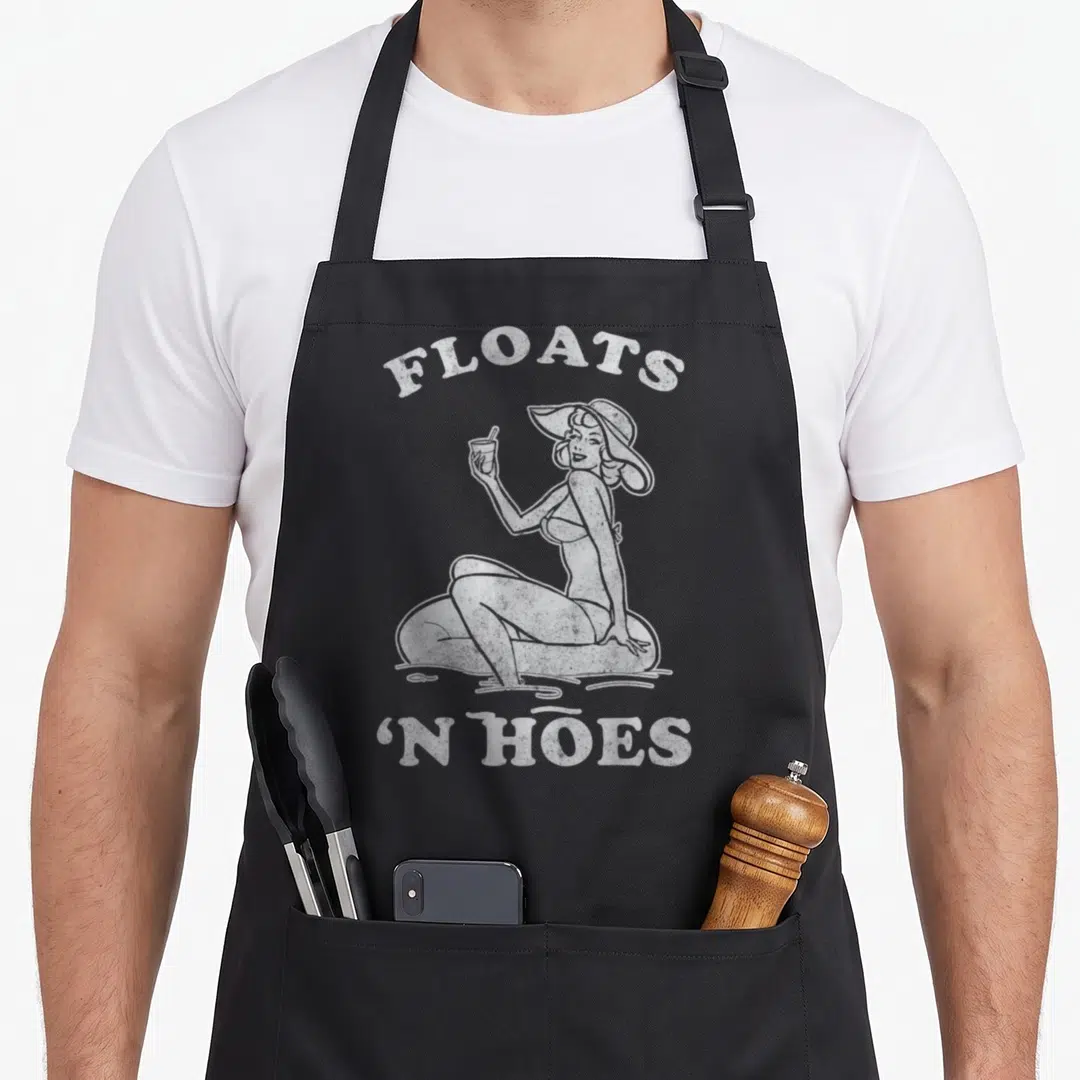 Trip floats apron - Distressed white woman on tube with FLOATS 'N HOES text — shown on a black cotton canvas apron against a white background