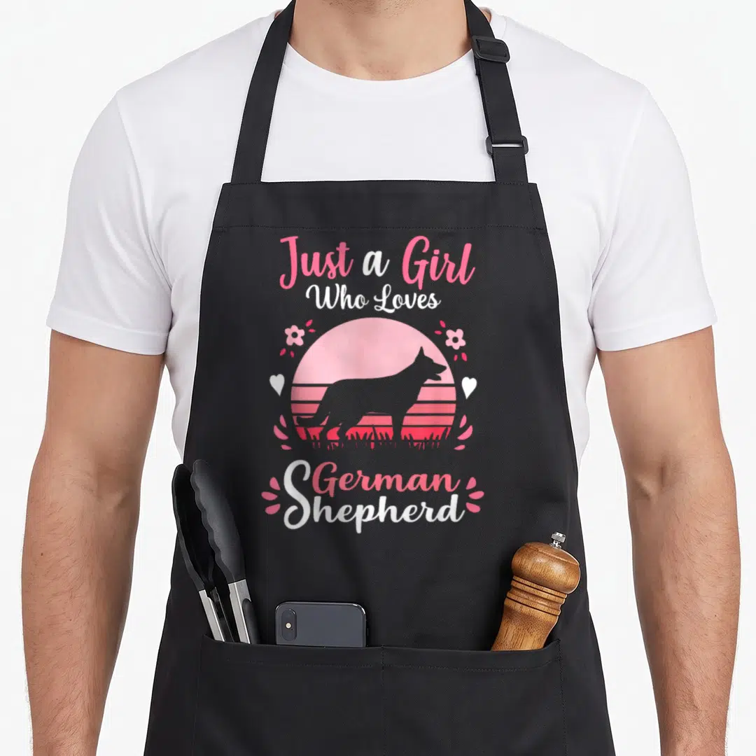 Retro german dog mom apron - Pink and white retro text Just a Girl Who Loves German Shepherd around sunset dog — shown on a black cotton canvas apron against a white background