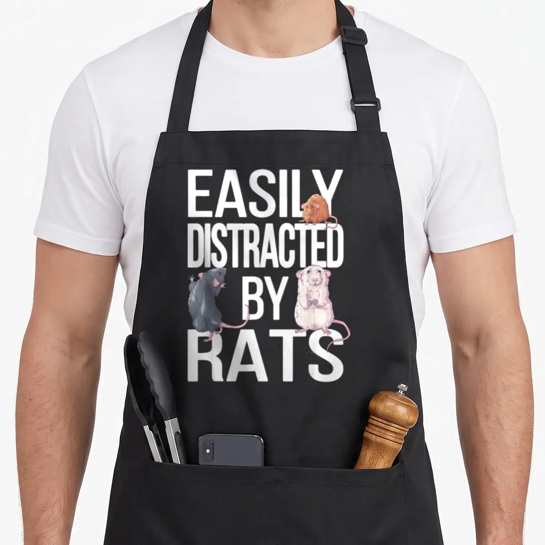 Easily pet apron - EASILY DISTRACTED BY RATS text with brown, grey, and white cartoon rats sitting on letters — shown on a black cotton canvas apron against a white background