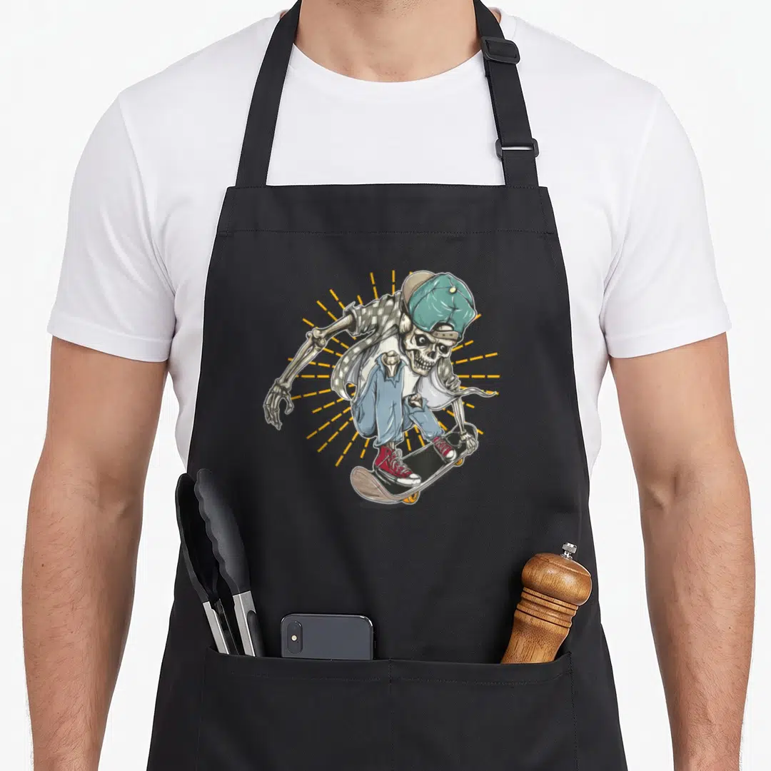 Cute skateboard skateboarding lover apron - Cartoon skeleton wearing teal cap and red shoes riding a skateboard — shown on a black cotton canvas apron against a white background
