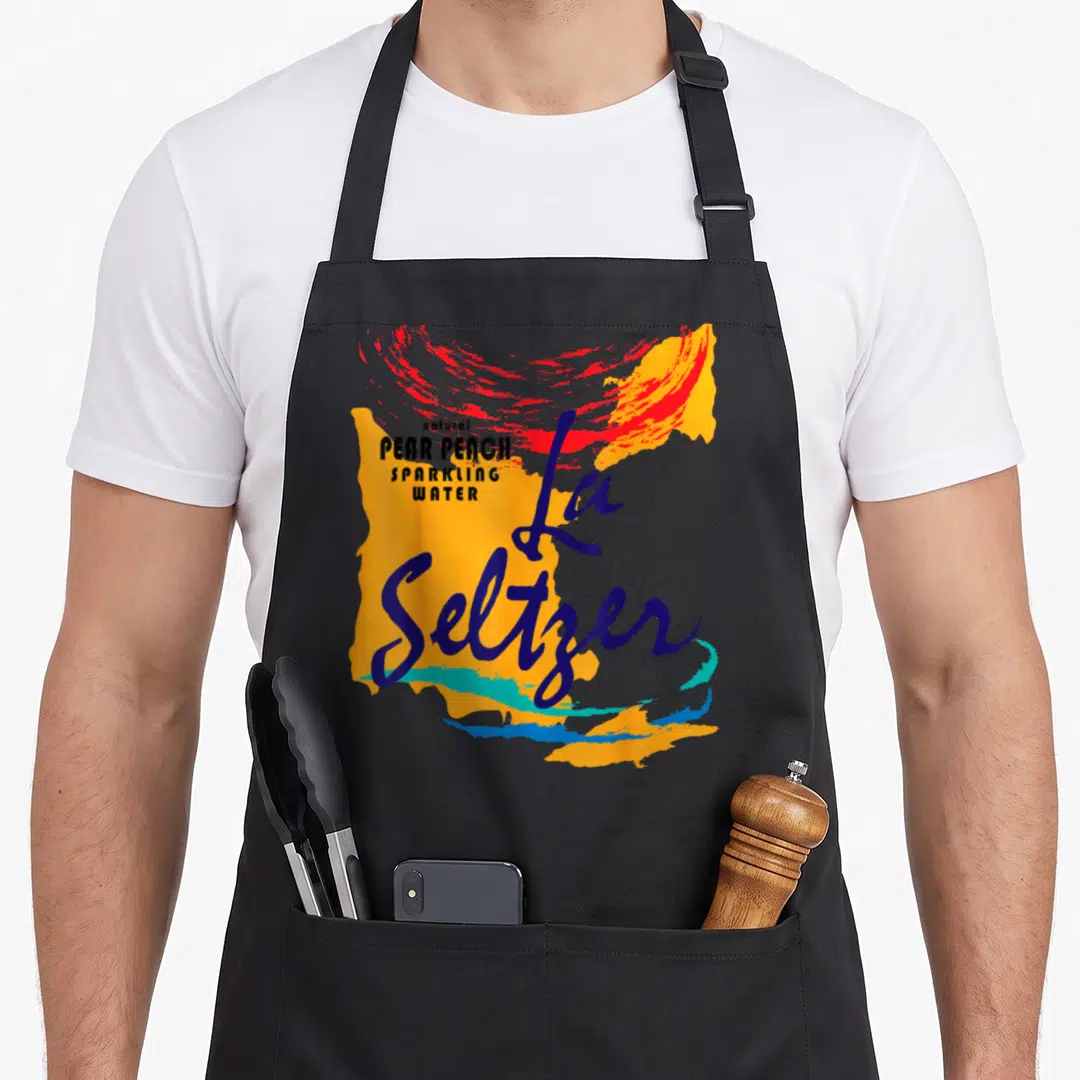 Pear halloween apron - Abstract orange and blue paint splashes with natural pear peach sparkling water text and La — shown on a black cotton canvas apron against a white background