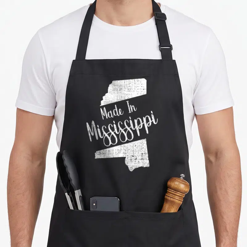 State mississippi river apron - White distressed Mississippi state map outline with Made In Mississippi text — shown on a black cotton canvas apron against a white background