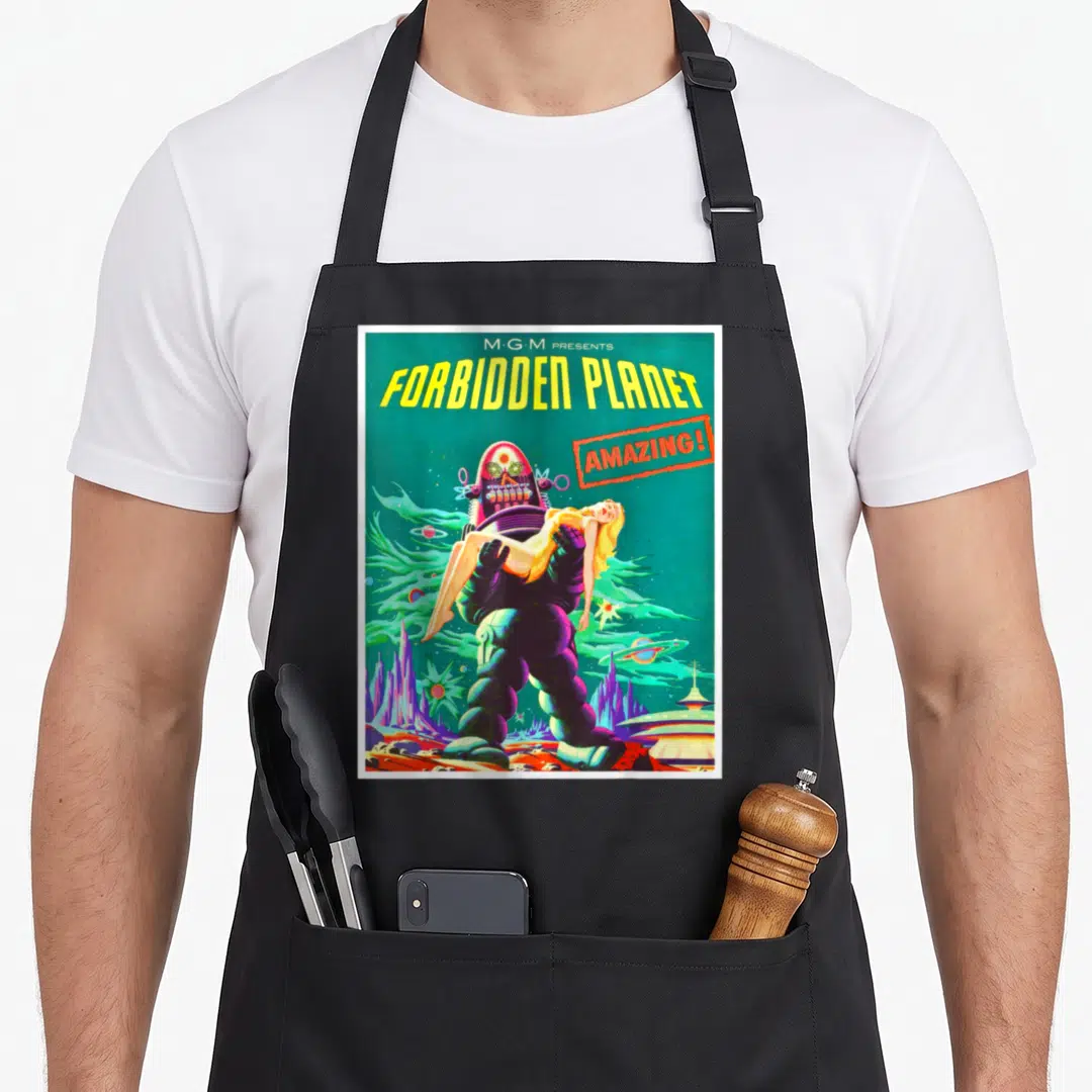 Horror science apron - Retro robot carrying woman in alien landscape with Forbidden Planet text — shown on a black cotton canvas apron against a white background