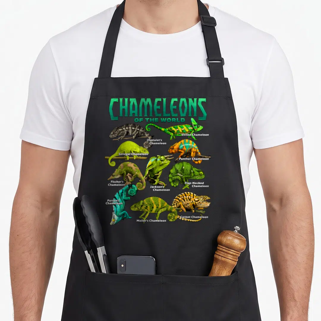 Educational chameleon apron - Twelve labeled chameleon species perched on brown branches in green, blue, orange — shown on a black cotton canvas apron against a white background
