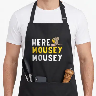Mice cute mouse apron - Stacked Here Mousey Mousey text with cartoon mouse holding yellow cheese wedge — shown on a black cotton canvas apron against a white background