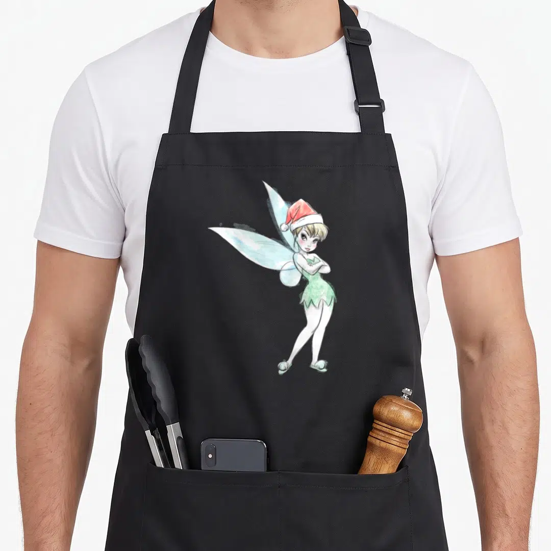 Peter santa aprons - Cartoon fairy with light blue wings wearing a red Santa hat and green dress with arms crossed — shown on a black cotton canvas apron against a white background