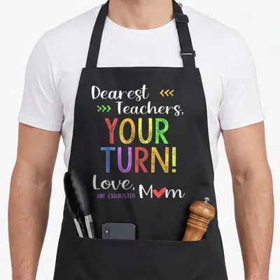 School cute teacher apron - Stacked text Dearest Teachers Your Turn Love Mom with red heart and multi-colored letters — shown on a black cotton canvas apron against a white background