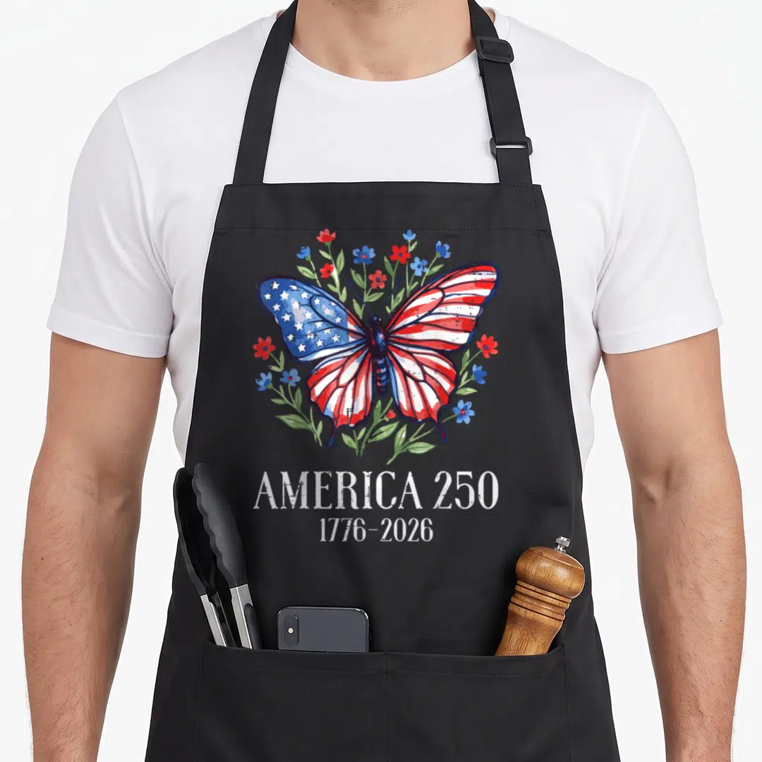 Flag 250th anniversary 4th of july apron - Butterfly with American flag wings surrounded by red white and blue flowers — shown on a black cotton canvas apron against a white background