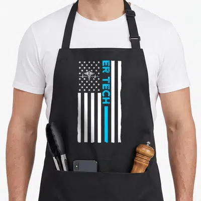 Technician us aprons - Vertical distressed flag with blue stripe, ER TECH text, and caduceus heartbeat symbol — shown on a black cotton canvas apron against a white background