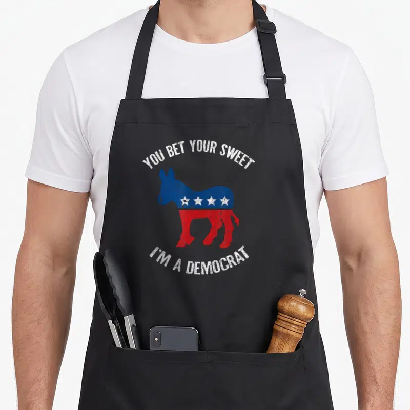 Bet midterms apron - Distressed blue and red donkey with white stars and arched text on black fabric — shown on a black cotton canvas apron against a white background
