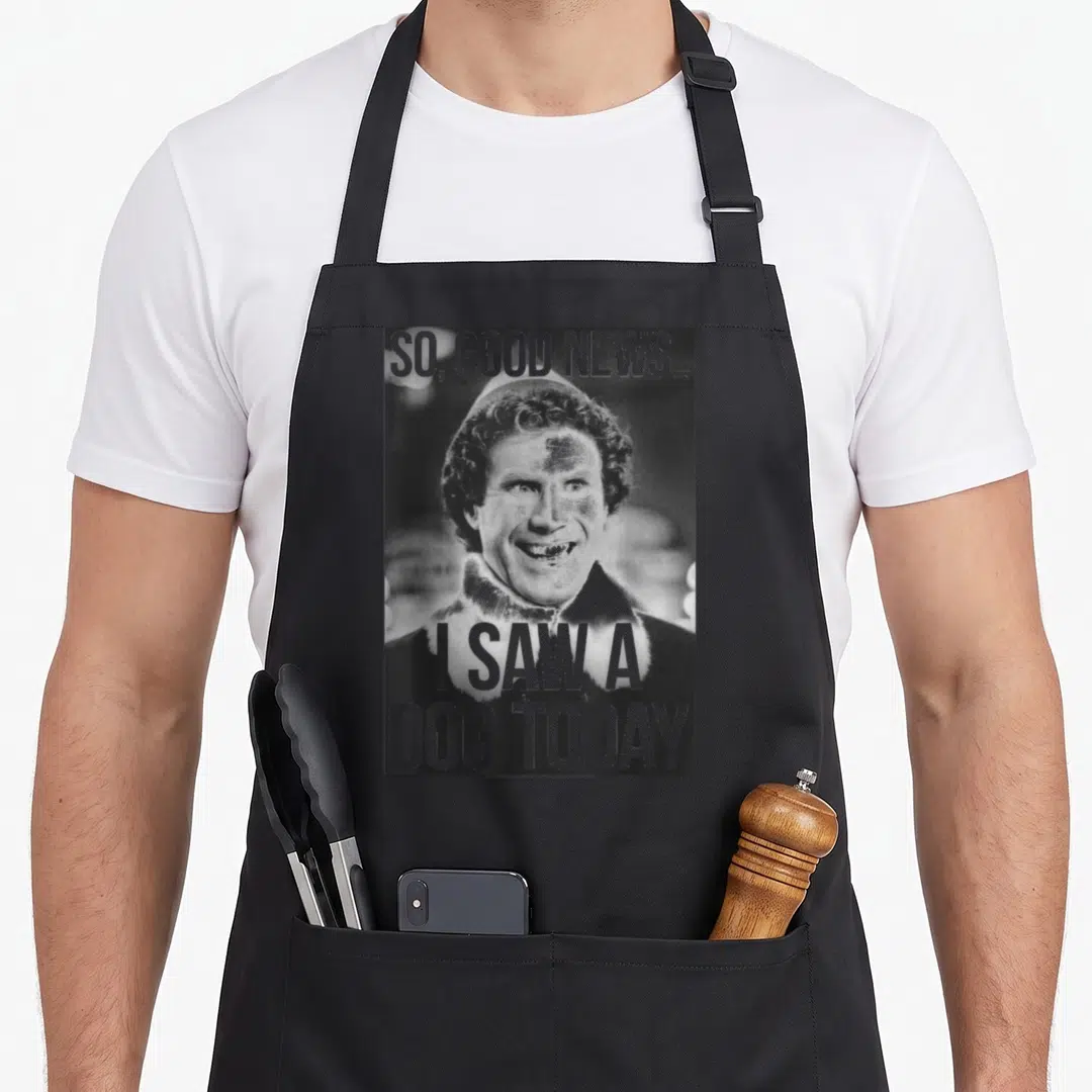 Elf dog apron - So good news i saw a dog today text over a smiling man photo — shown on a black cotton canvas apron against a white background
