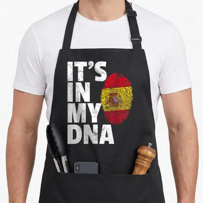 Dna spanish aprons - Stacked IT'S IN MY DNA text beside a red yellow white Spanish flag fingerprint with distressed — shown on a black cotton canvas apron against a white background