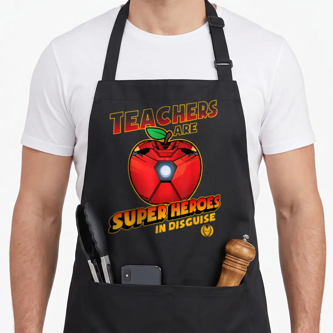 Vintage heroe teacher apron - Red mechanical apple with arched TEACHERS ARE SUPER HEROES IN DISGUISE text and small — shown on a black cotton canvas apron against a white background
