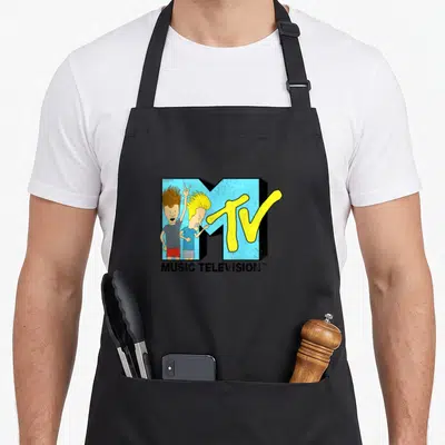 Beavis heavy apron - MTV logo with two cartoon characters in blue, yellow, and black — shown on a black cotton canvas apron against a white background