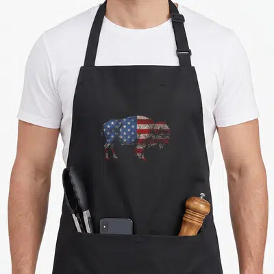 Bison american flag apron - Distressed bison silhouette filled with red white blue stars and stripes pattern — shown on a black cotton canvas apron against a white background
