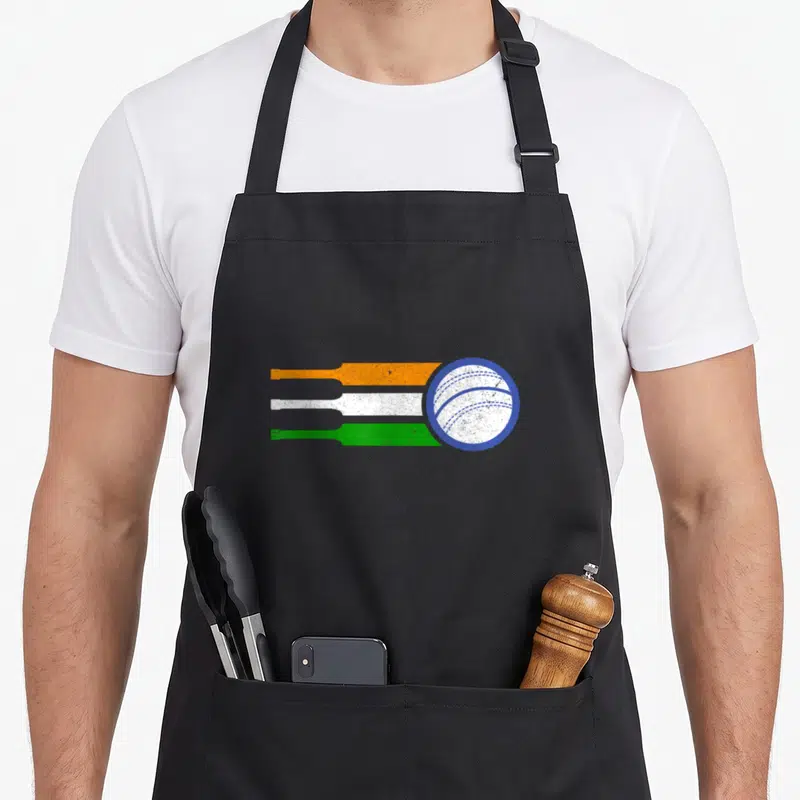 India cricket apron - White cricket ball with blue seams and three horizontal lines in orange, white, and green — shown on a black cotton canvas apron against a white background