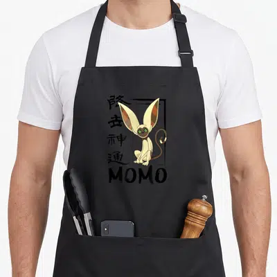 Momo avatar the last airbender apron - Cartoon aye-aye with vertical kanji and MOMO text in beige brown and black — shown on a black cotton canvas apron against a white background