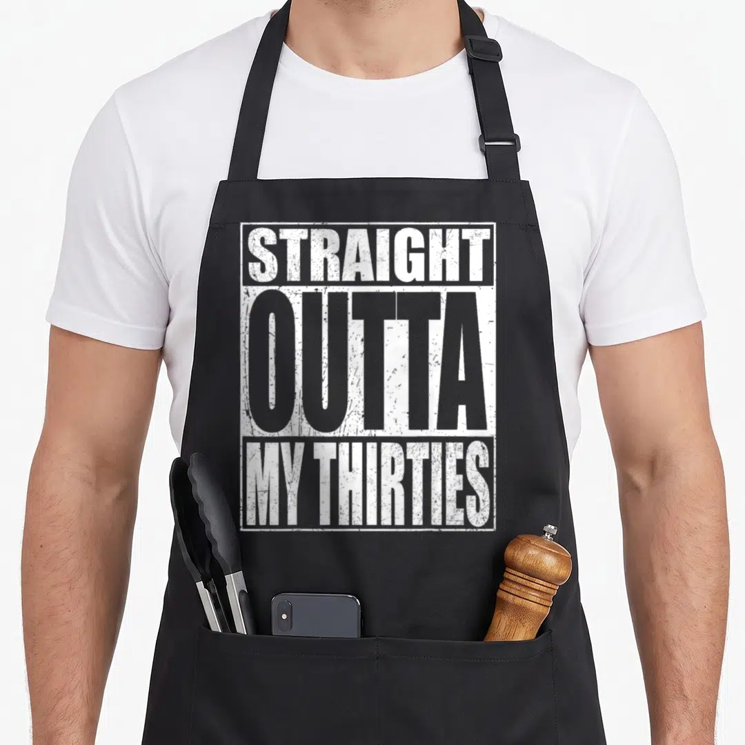 Straight 40th birthday apron - White distressed text reading STRAIGHT OUTTA MY THIRTIES stacked in a rectangle — shown on a black cotton canvas apron against a white background
