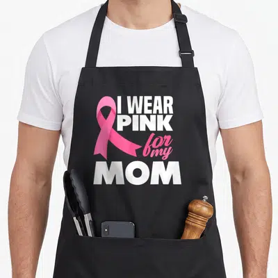 Mother breast cancer awareness aprons - Pink ribbon overlapping stacked white and pink text reading I WEAR PINK for my — shown on a black cotton canvas apron against a white background