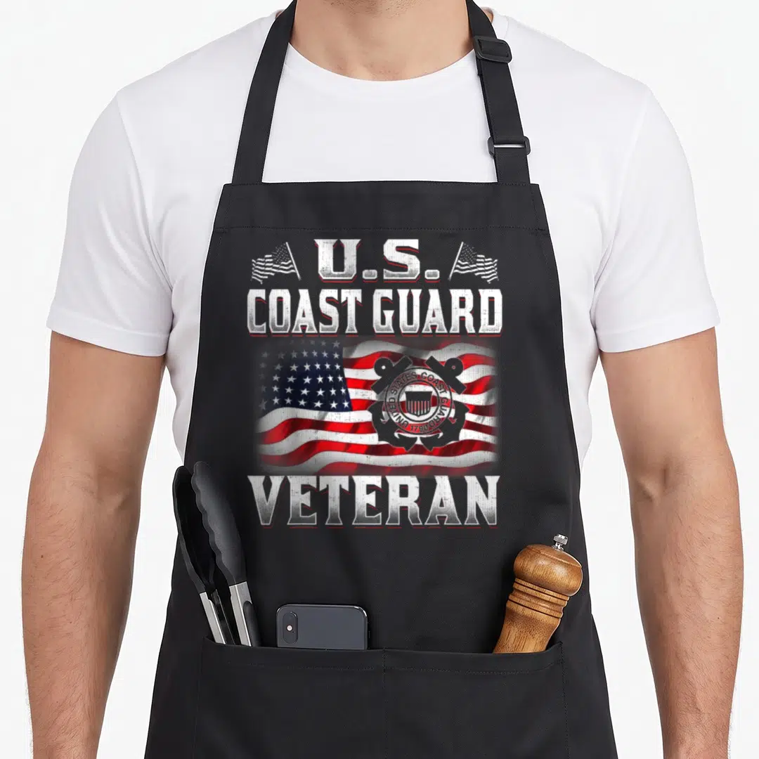 Coast vet apron - Distressed U.S. Coast Guard Veteran text with waving American flag and emblem in red white blue silver — shown on a black cotton canvas apron against a white background