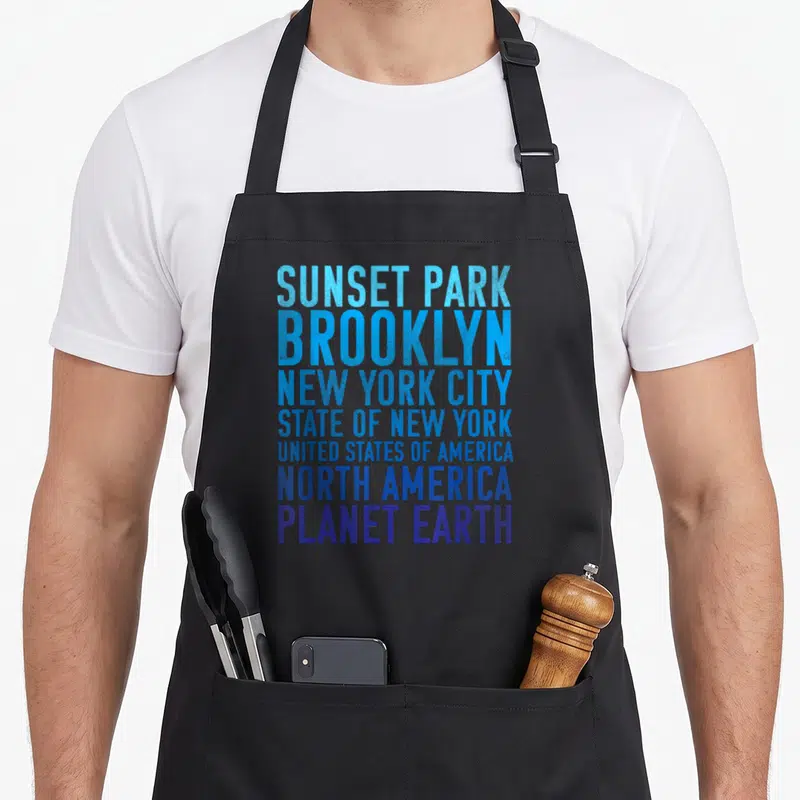 Earth new york apron - Stacked text listing Sunset Park Brooklyn New York City State USA North America Planet Earth — shown on a black cotton canvas apron against a white background