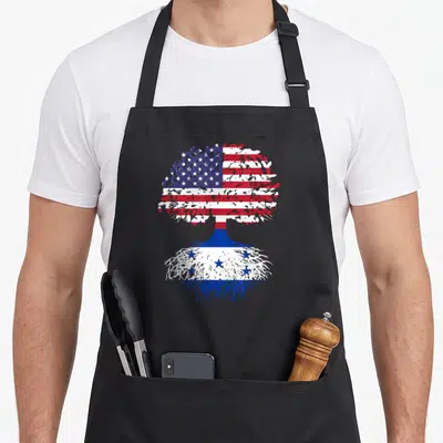 Honduran tree apron - Tree with US flag canopy and Honduras flag roots in blue white red line art — shown on a black cotton canvas apron against a white background