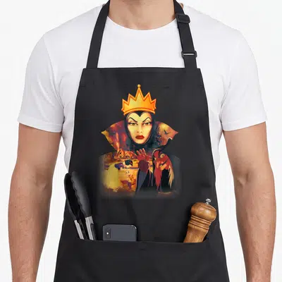 Evil snow white apron - Evil Queen face above witch holding apple and Snow White near cottage in cartoon style — shown on a black cotton canvas apron against a white background