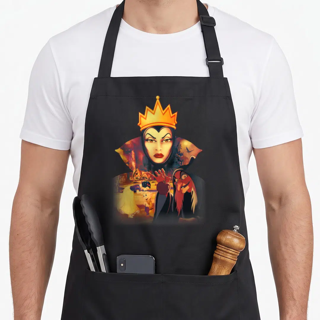 Evil snow white apron - Evil Queen face above witch holding apple and Snow White near cottage in cartoon style — shown on a black cotton canvas apron against a white background