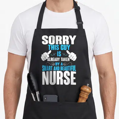 Husband nurse apron - White and blue text Sorry This Guy Is Taken By A Smart And Beautiful Nurse with two thumbs up — shown on a black cotton canvas apron against a white background