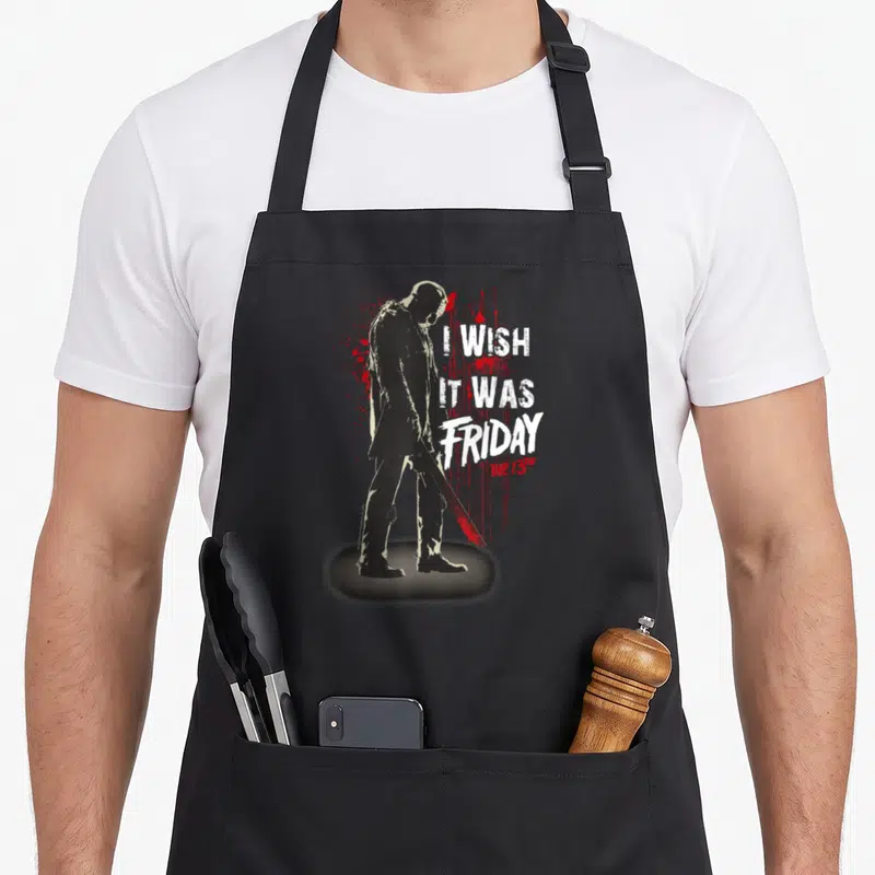Jason novelty apron - Distressed black silhouette of Jason holding a machete next to red blood splatters and white text — shown on a black cotton canvas apron against a white background